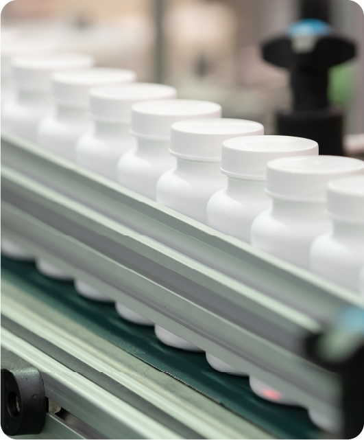 Carousel of white pill bottles full of supplements ready to be labeled