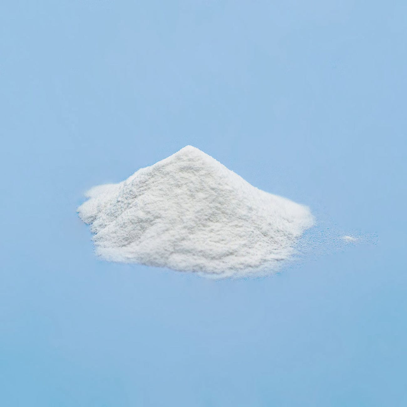 Microcrystalline Cellulose 101-Pile of white Microcrystalline Cellulose 101 Powder on light blue background-Excipient-Granules